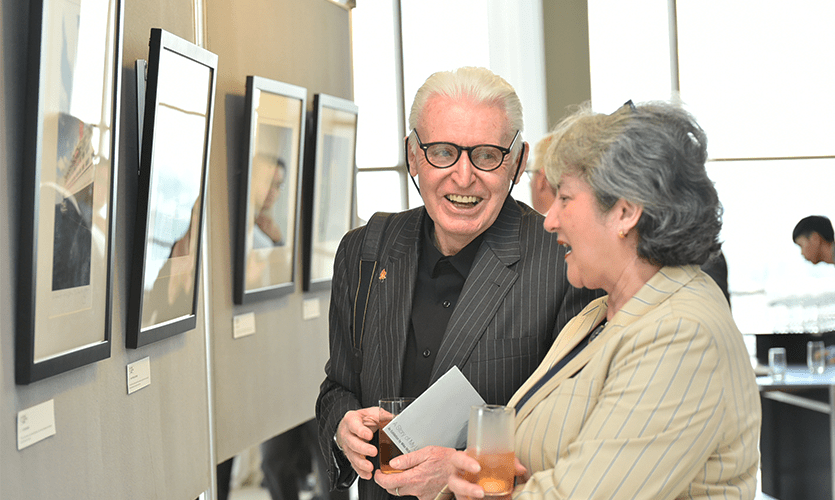 Mike McCartney discussing one of his images with an exhibition guest.